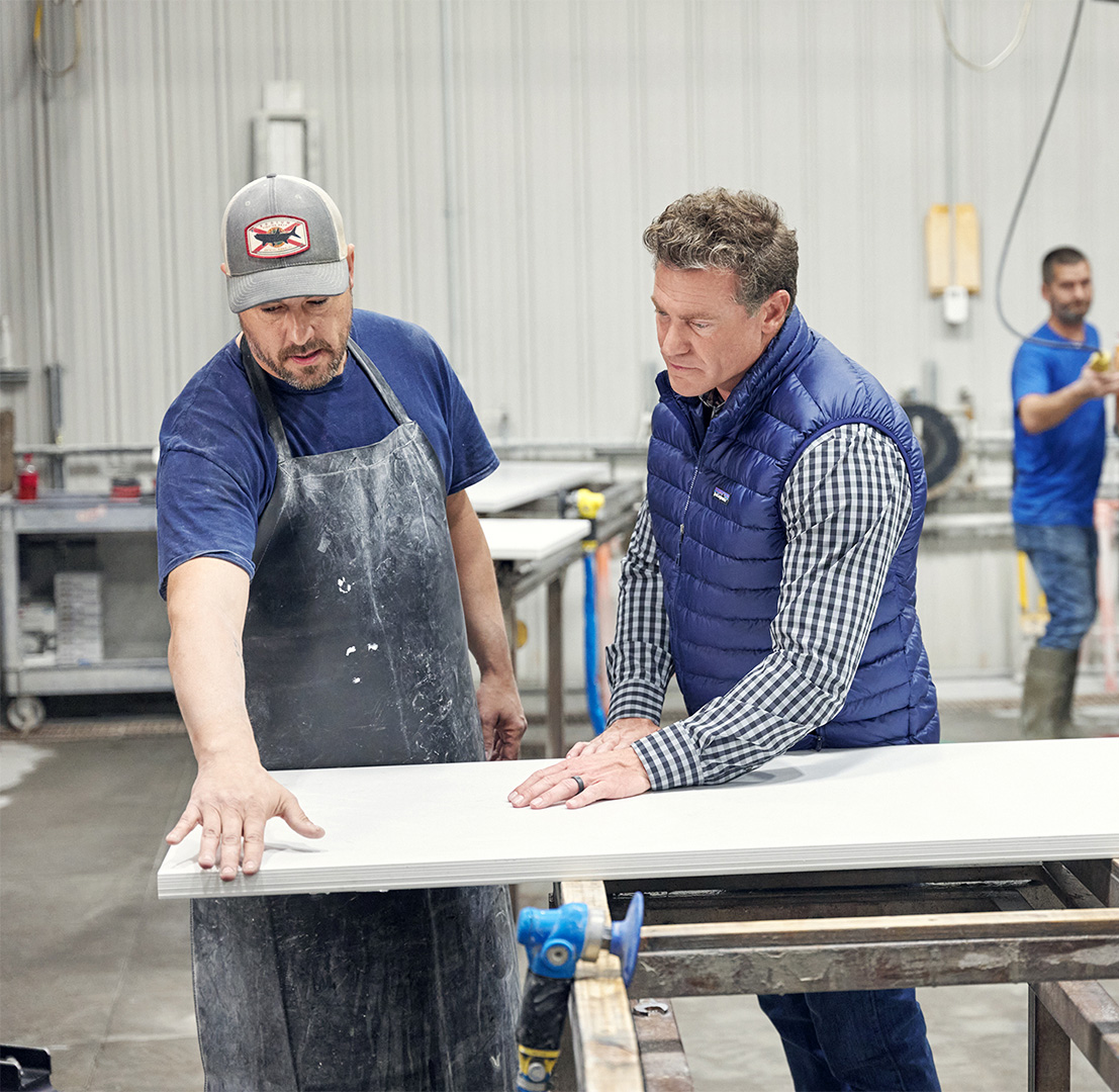 Chris Garten looking at countertops with a worker in a fabrication shop