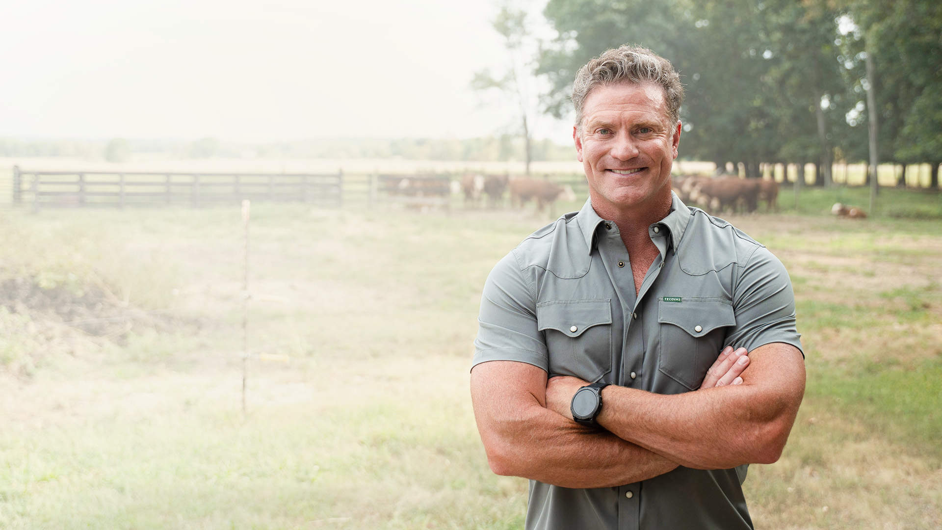 Chris Garten standing on a farm with his arms crossed